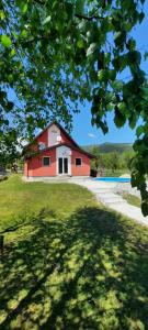 uma casa vermelha com uma piscina em frente em Smjestaj na selu Stankovic - Pliva em Šipovo