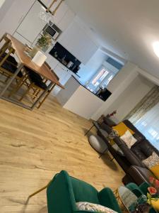 sala de estar con sofá verde y cocina en Apartamento bonito, en Lugones