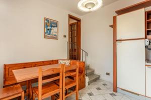 a dining room with a wooden table and a refrigerator at Casa Luana San Concordio - Affitti Brevi Italia in Lucca +11 photos