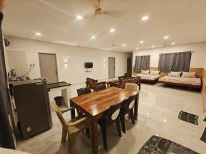 a living room with a wooden table and chairs at SAIBALA HOMESTAY - AC 5 BHK NEAR AlRPORT in Chennai