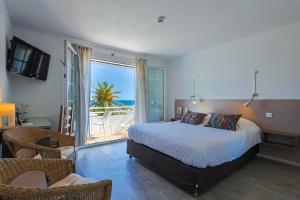 um quarto com uma cama e vista para o oceano em Logis Hotel l'Esterella em Agay - Saint-Raphaël