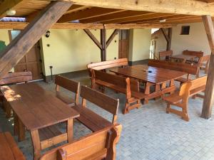 an empty room with wooden tables and chairs at Apartmány s klimatizací - Penzion U Kudláčků Pouzdřany in Pouzdřany