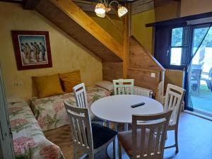 a room with a table and chairs and a bed at PENSION ALFOZ de RONDIELLA in Piñeres
