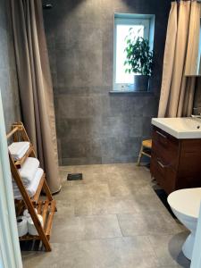 a bathroom with a shower and a sink at Boende med hotellkänsla i populära Skrea, Falkenberg in Falkenberg