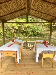 two tables in a pavilion with flowers on a deck at La Chagra vip in Villavicencio