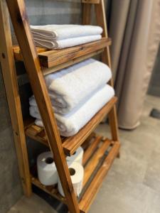 a wooden towel rack with towels and toilet paper at Boende med hotellkänsla i populära Skrea, Falkenberg in Falkenberg