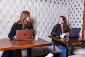 two women sitting at a table with their laptops at Hotel 1711 in Valkenburg