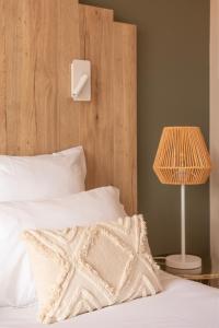 łóżko z białą poduszką i lampą w obiekcie Hôtel BO & MIA w mieście La Baule-Escoublac