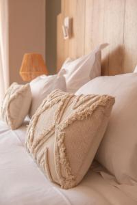 ein weißes Bett mit weißen Kissen darauf in der Unterkunft Hôtel BO & MIA in La Baule