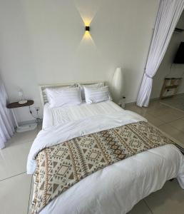 a bedroom with a large bed with white sheets and pillows at The Borneo Suite - Group of 6 - 9 pax in Kota Kinabalu