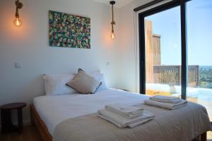 a bedroom with a white bed with towels on it at Caju Villas Montargil - Villa Vale Vilão in Montargil