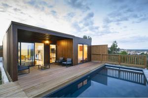 uma casa com um deque de madeira e uma piscina em Caju Villas Montargil - Villa Vale Vilão em Montargil