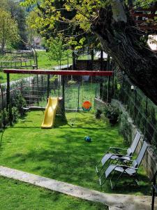 Valea Doftanei的住宿－Tiny House Căsuța cocoțată - Valea Doftanei - 2camere，公园设有带滑梯和两把椅子的游乐场