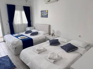 a room with two beds and a living room at White and Blue Bodrum in Bodrum City