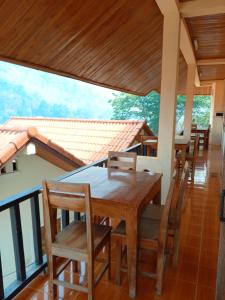 a dining room with a table and chairs on a balcony at Cam U View Bungalow in Nongkhiaw