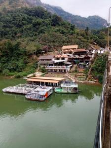 un groupe de bateaux amarrés sur une rivière dans l'établissement Cam U View Bungalow, à Nongkhiaw