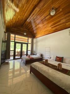 1 Schlafzimmer mit 2 Betten und Holzdecke in der Unterkunft Cam U View Bungalow in Nongkhiaw