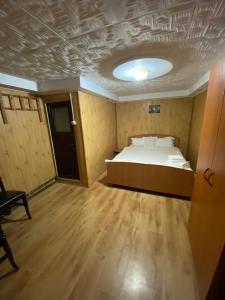 1 dormitorio con 1 cama en una habitación con suelo de madera en Sinaia Rooms 25, en Sinaia