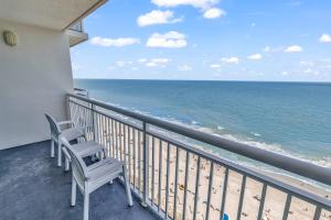 two chairs sitting on a balcony looking at the ocean at Carolinian Resort 2032 in Myrtle Beach