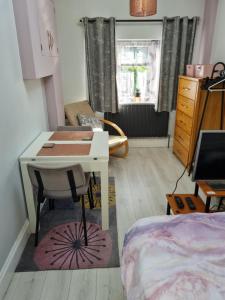 um pequeno quarto com uma secretária e uma cama em 1 Bed Annex 2 mins from Harlow Mill train station em Harlow