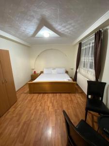 1 dormitorio con 1 cama y suelo de madera en Sinaia Rooms 25, en Sinaia
