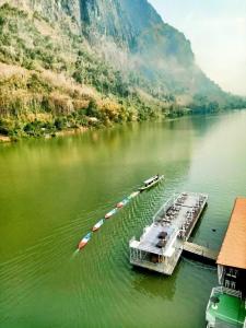 eine Gruppe von Booten, die an einem Dock auf einem Fluss angedockt sind in der Unterkunft Cam U View Bungalow in Nongkhiaw