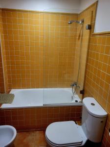 W wyłożonej pomarańczowymi kafelkami łazience znajduje się toaleta i wanna. w obiekcie LA CASITA DE LAS HADAS w mieście Biar