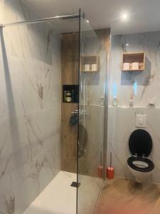 een badkamer met een glazen douche en een toilet bij Magnifique 3 p vue mer proche Monaco in Roquebrune-Cap-Martin
