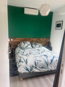 een slaapkamer met een bed met een groene muur bij Magnifique 3 p vue mer proche Monaco in Roquebrune-Cap-Martin