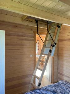 a ladder in the ceiling of a tiny house at Domki caloroczne Przytulisko na Mazurach in Ruciane-Nida