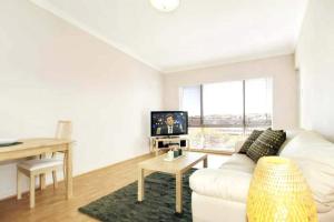 - un salon avec un canapé blanc et une table dans l'établissement Acacia Holiday Or Business Stay - Quiet Location, à Perth