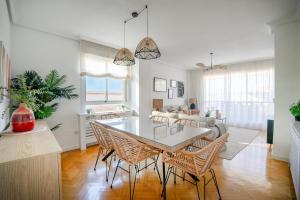a kitchen and living room with a table and chairs at Ático con terraza, parking y piscina in Madrid