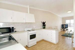 a kitchen with white cabinets and a counter top at Acacia Holiday Or Business Stay - Quiet Location in Perth