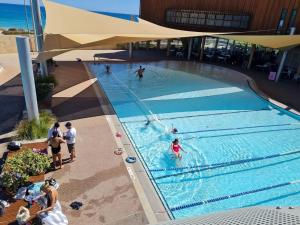 a group of people swimming in a swimming pool at Acacia Holiday Or Business Stay - Quiet Location in Perth