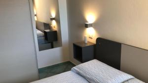una piccola camera con letto e specchio di Pelosa - Capo Falcone Excellent Apartment a Stintino