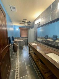 La salle de bains est pourvue de 2 lavabos et d'un grand miroir. dans l'établissement Upscale River Rock Lake House, Pet Friendly, à Hawkins