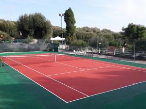 un campo da tennis con rosso e verde di Villaggio Residence Villamarina a Marina di Camerota