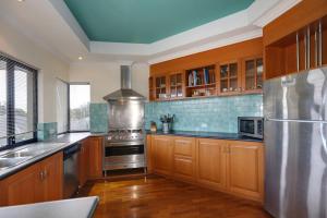 a large kitchen with wooden cabinets and a blue ceiling at Rancho Relaxo - Great For Longer Stays! Free Wifi in Perth