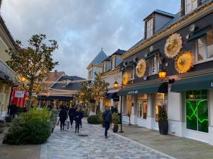 a group of people walking down a street at Jade Apart Bussy Centre Disney 10min in Bussy-Saint-Georges