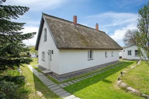 an old white house with a thatched roof at Reetferienhaus Lütt in Schaprode