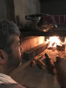 a man is cooking hot dogs in an oven at Abrigo Cantareira in Mairiporã