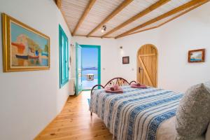 a bedroom with a bed with a blue and white blanket at Akron Terra Houses in Akrotiri