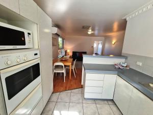 uma cozinha com armários brancos e um micro-ondas em Ocean's "4" Holiday Or Business Stay Accommodation em Perth