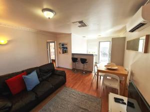 uma sala de estar com um sofá e uma mesa em Ocean's "4" Holiday Or Business Stay Accommodation em Perth