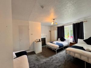 a bedroom with two beds and a fireplace in it at High Trees Guest House Gatwick in Hookwood
