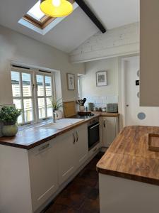 a kitchen with white cabinets and a wooden counter top at Chester City Centre townhouse in Chester