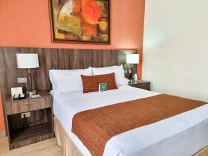a hotel room with a large bed and two lamps at Hotel Arizona Suites Cúcuta in Cúcuta +69 photos