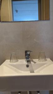 a bathroom sink with two glasses and a mirror at Hotel 1711 in Valkenburg
