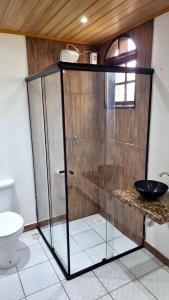 W łazience znajduje się przeszklony prysznic i toaleta. w obiekcie Chalé 09 com cozinha no coração de penedo w mieście Itatiaia