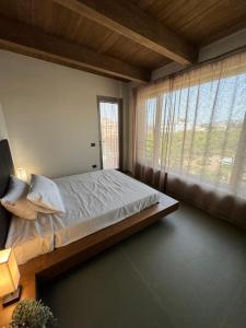 sypialnia z łóżkiem i dużym oknem w obiekcie Penthouse Rooms Marigliano - Eleganza sopra le nuvole w mieście Marigliano